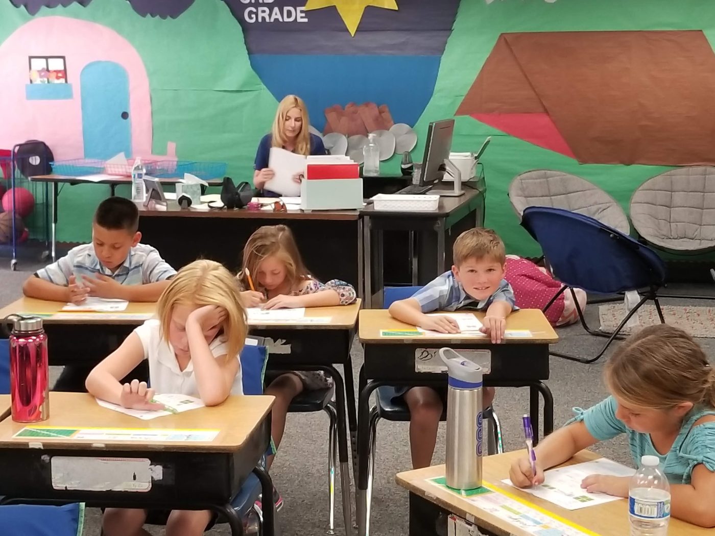 Students at desks in a colorfully decorated classroom