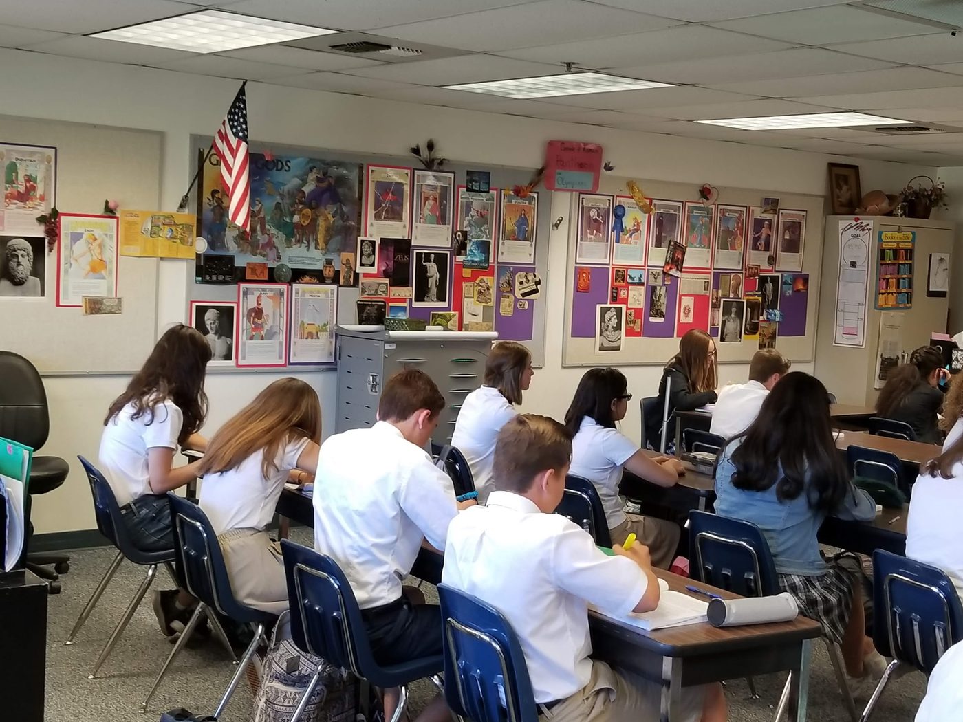 Students in a classroom decorated with flags
