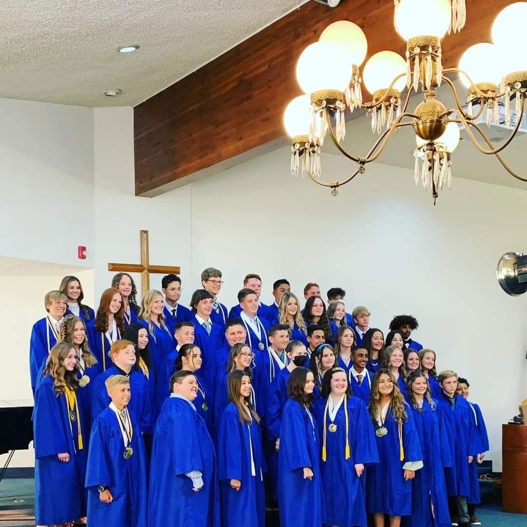 Graduating students on stage in caps and gowns